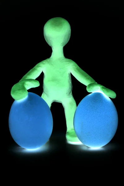 Shaded puppet of plasticine holding two eggs — Stock Photo, Image