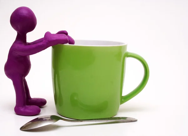 Paarse marionet van plasticine rest op cup — Stockfoto
