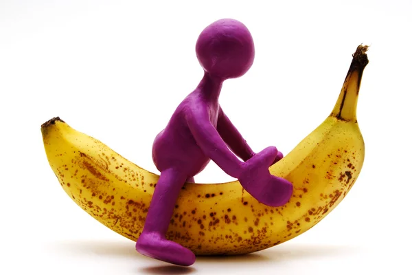 Fantoche roxo de plasticina montando na banana — Fotografia de Stock