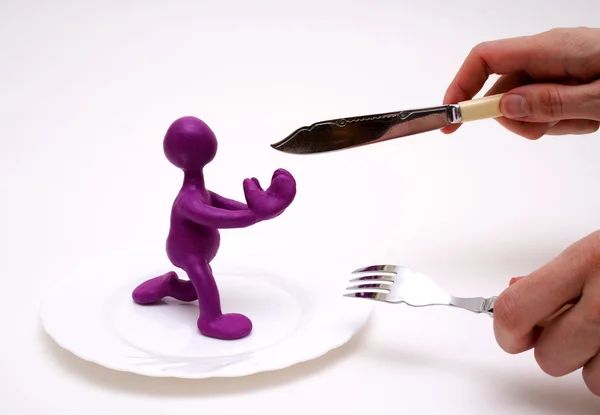 Marioneta púrpura de plastilina rogando por la vida — Foto de Stock