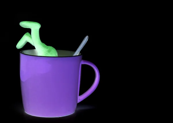 Shaded puppet of plasticine sinking in cup — Stock Photo, Image