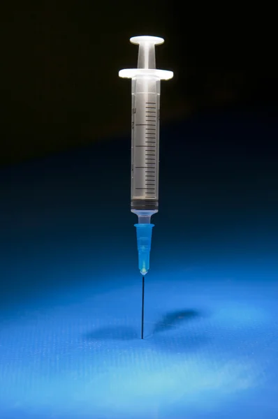 Ready medical syringe standing head down — Stock Photo, Image
