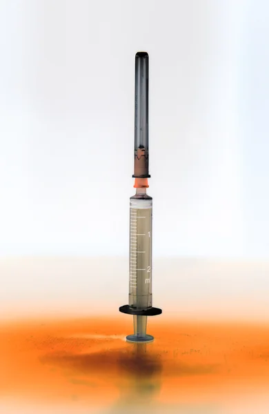 Shaded medical syringe standing head up — Stock Photo, Image