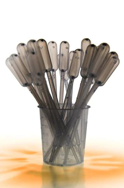 Shaded pipettes standing placed in measure glass — Stock Photo, Image
