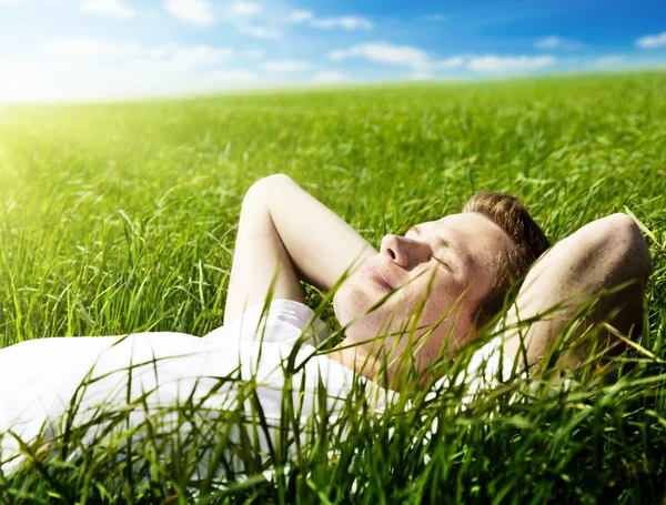 Jeune homme dans l'herbe de printemps — Photo
