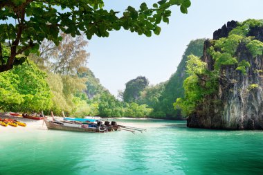 Long boats on island in Thailand clipart