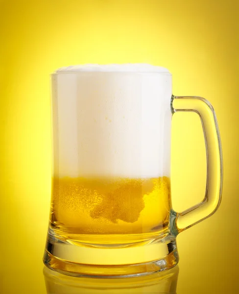 黄色の背景上の泡のクローズ アップはビールのグラス — ストック写真