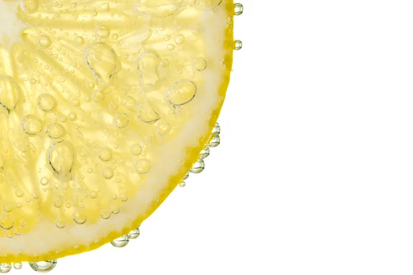 Bubbles on a lemon segment in soda water — Stock Photo, Image