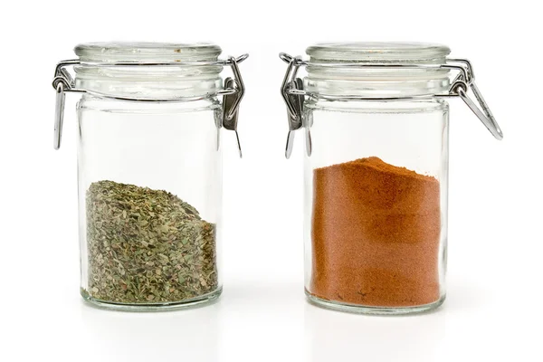 Red pepper powder and oregano in jars — Stock Photo, Image