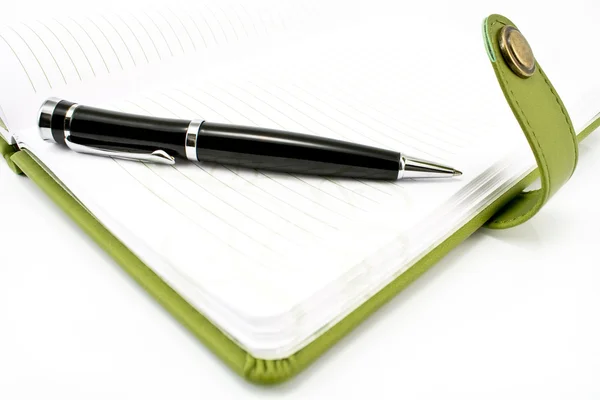 Ручка и зеленая тетрадь — стоковое фото