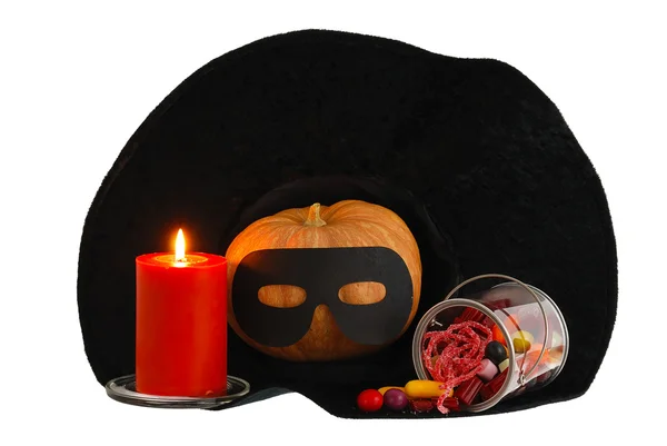 Caramelos de Halloween con vela y calabaza en sombrero de bruja aislado —  Fotos de Stock