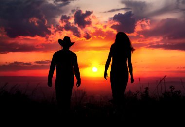 Cowboy couple silhouette at sunset clipart