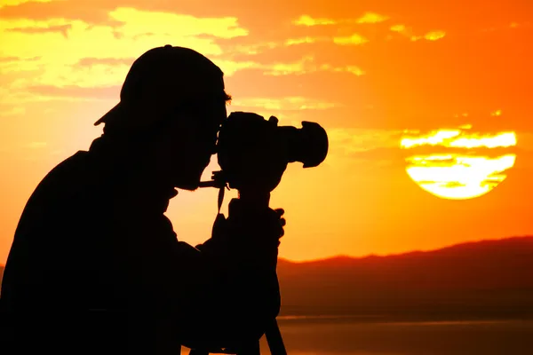 Sylwetka fotografa o zachodzie słońca — Zdjęcie stockowe