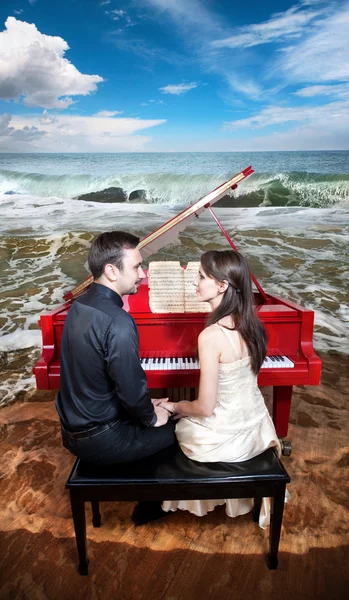 Пара рядом с пианино на пляже — стоковое фото