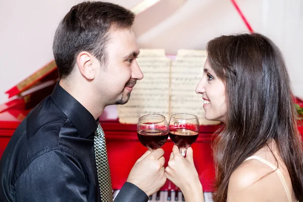 stock image Couple with glasses of wine near piano
