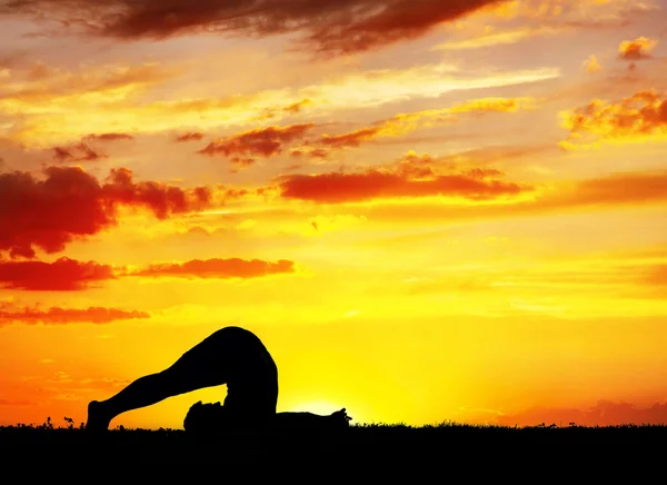 Silhouette yoga Halasana aratro posa — Foto Stock