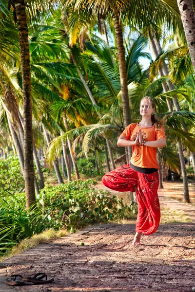 Postura del vrikshasana del yoga en bosque de palma — Foto de Stock