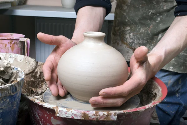 De handen van een pottenbakker, maken een aarden pot op de cirkel — Stockfoto