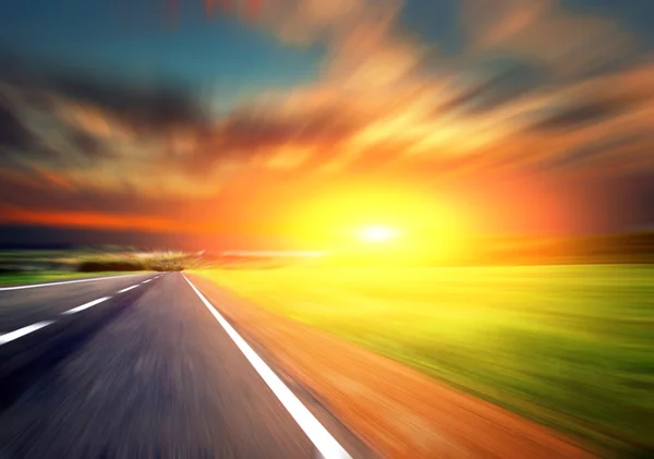 Estrada desfocada com céu desfocado e pôr do sol — Fotografia de Stock