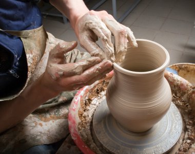 Hands of a potter, creating an earthen jar on the circle clipart