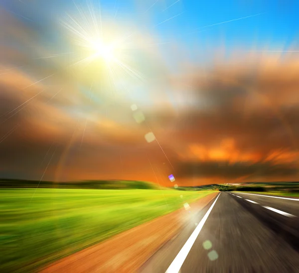 Road and blured sky with sun — Stock Photo, Image