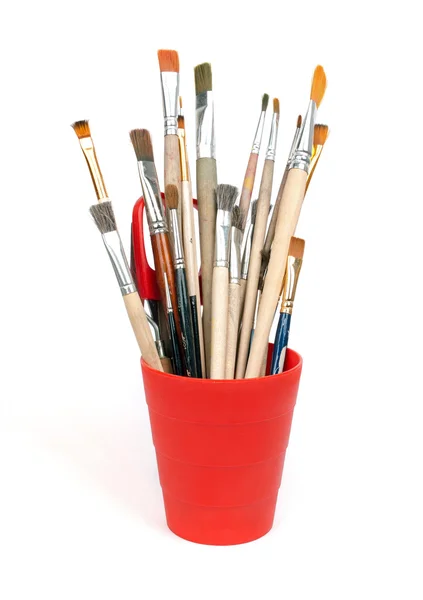 Paint brushes in red glass — Stock Photo, Image
