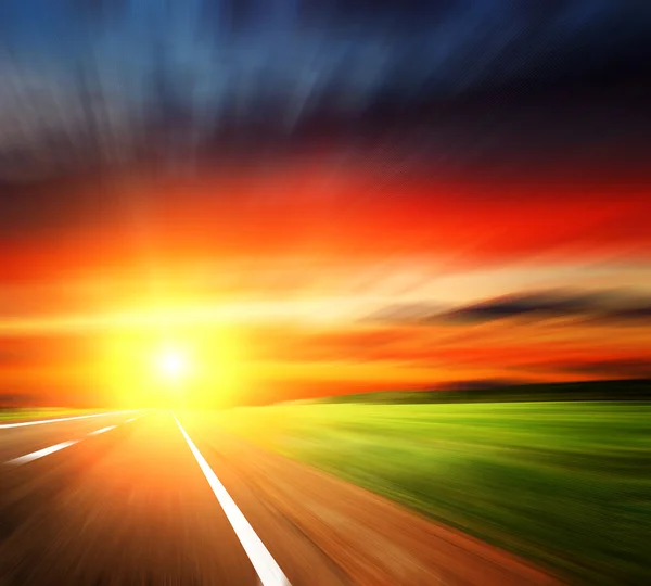 Suddig road med suddiga himmel med solnedgång — Stockfoto