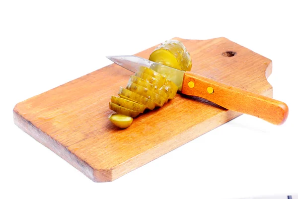 Огірок нарізаний на ріжучій дошці і кухонний ніж ізольований на білому — стокове фото