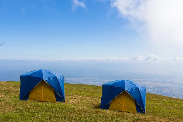 Duas tendas em uma grama sob o céu azul — Fotografia de Stock