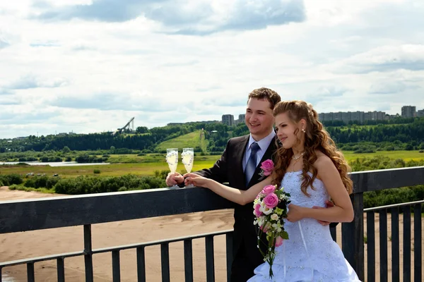 Wedding couple in sunny summer day stand on bridge — Stock Photo, Image