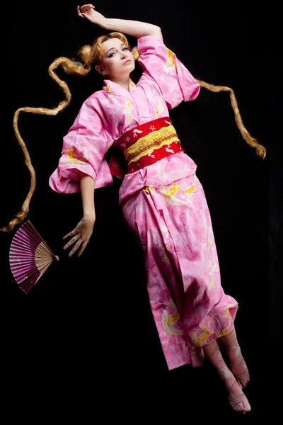 Jeune femme blonde couchée au Japon kimono sur noir — Photo