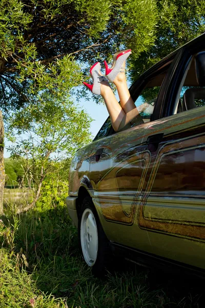 Jovem mulher sexy colocar no carro pernas para fora — Fotografia de Stock