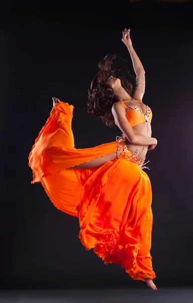 Beauty dancer jump in orange veil - arabian style — Stock Photo, Image