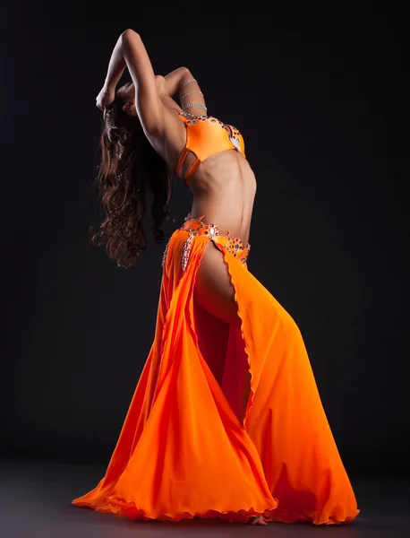 Експресивна жінка позує в помаранчевому арабському костюмі — стокове фото