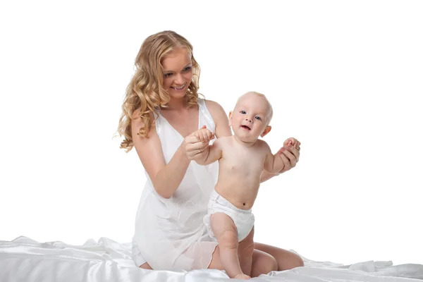 Skönhet blond mor spela med son i sängen — Stockfoto