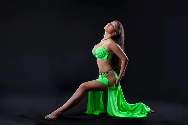 Красивая молодая девушка танцует в зеленом арабском костюме — стоковое фото