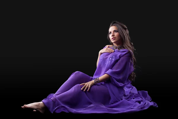 Молода дівчина лежала в фіолетовому традиційному костюмі — стокове фото