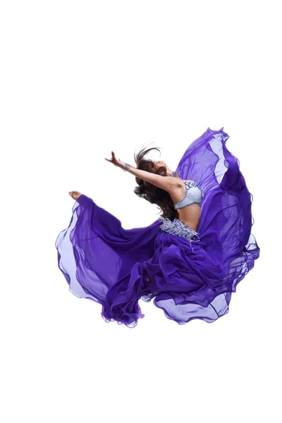 Junges Mädchen springt in lila orientalischen Schleier — Stockfoto