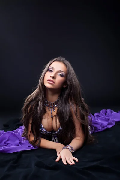 美阿拉伯舞者躺在紫色的面纱 — 图库照片