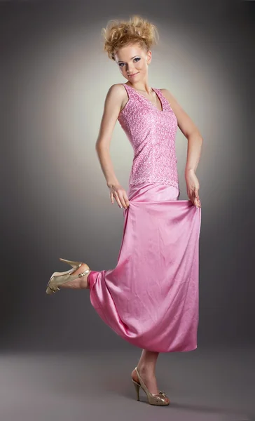 Hübsche blonde Frau tanzt in rosa Kleidern — Stockfoto