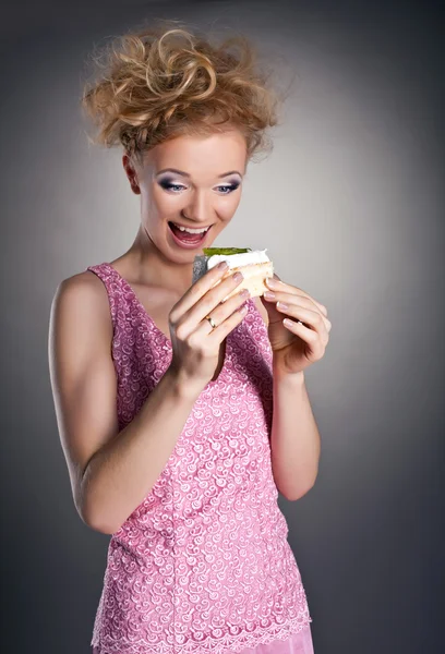 Söpö blondi onnellinen nainen syö kakkua — kuvapankkivalokuva
