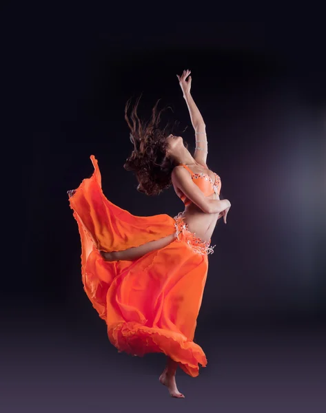 Piękna tancerka skok w pomarańczowy welon - stylu arabskiego — Zdjęcie stockowe