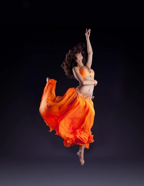 Bailarina de belleza salto en velo naranja - estilo árabe — Foto de Stock