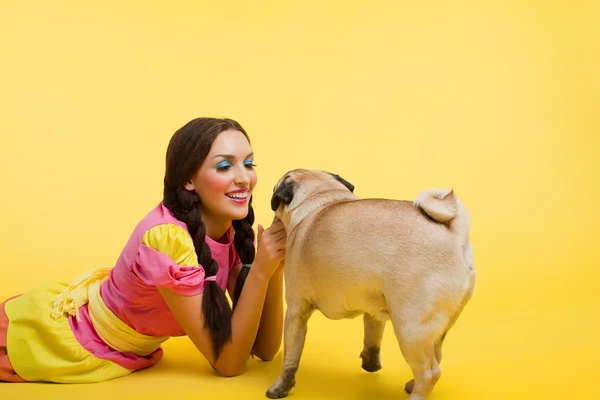 stock image Happy wwoung woman in doll dress feed a small dog