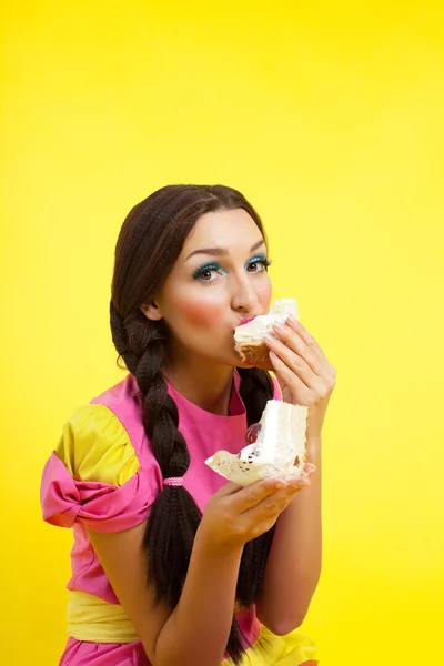 Mulher jovem come dois bolos - estilo de boneca pin-up — Fotografia de Stock