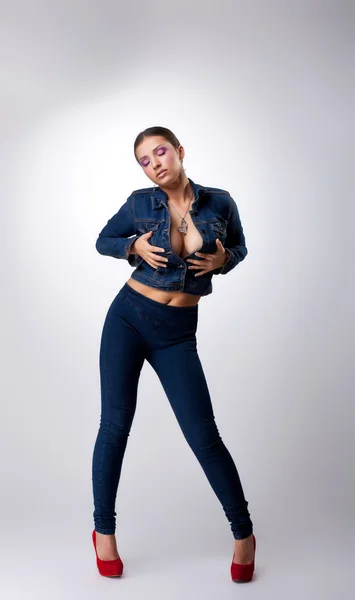 Ragazza sexy posa in abito jeans - prendere il seno — Foto Stock