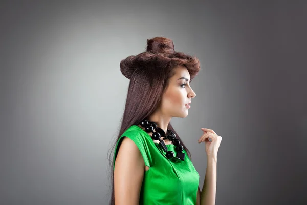 Aranyos nő haját stílusú kalapot - zöld ruhában pózol — Stock Fotó