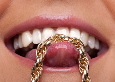 Beauty woman lips and gold chain on tongue clipart