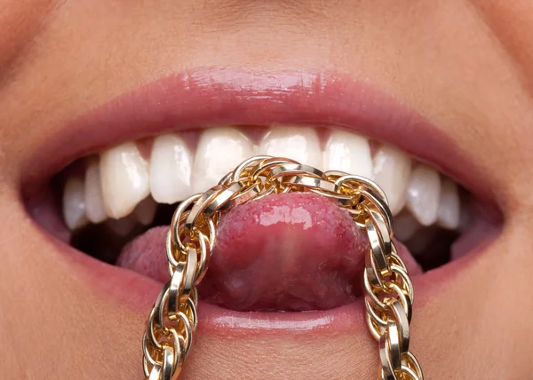 Красивая женщина губы и золотая цепь на языке — стоковое фото