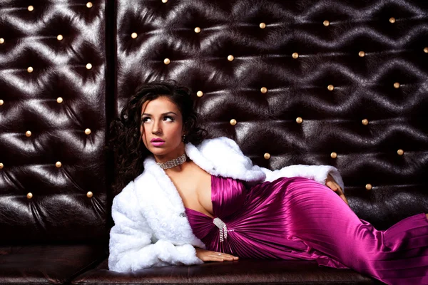 Beauty woman lay on leather sofa — Stockfoto